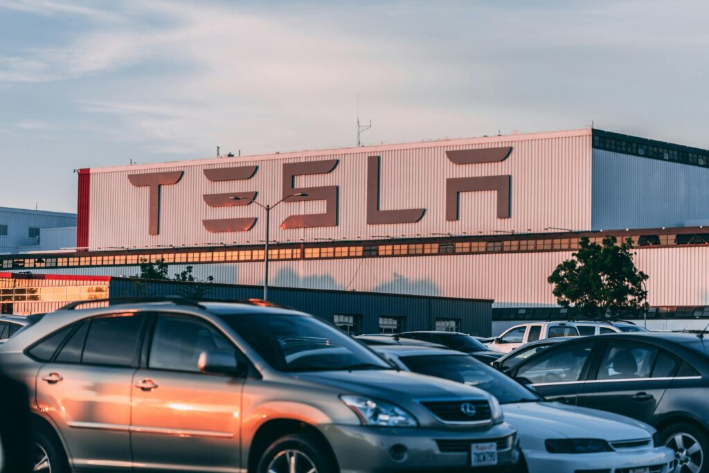 Tesla Powerwall Tesla factory with parked cars during sunset, showcasing modern automotive industry vibes.