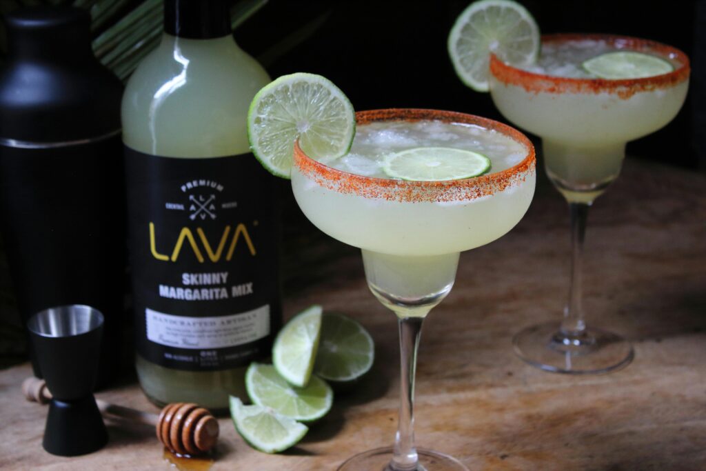 Close-up of a refreshing margarita with lime slice on a wooden table, ready to enjoy.