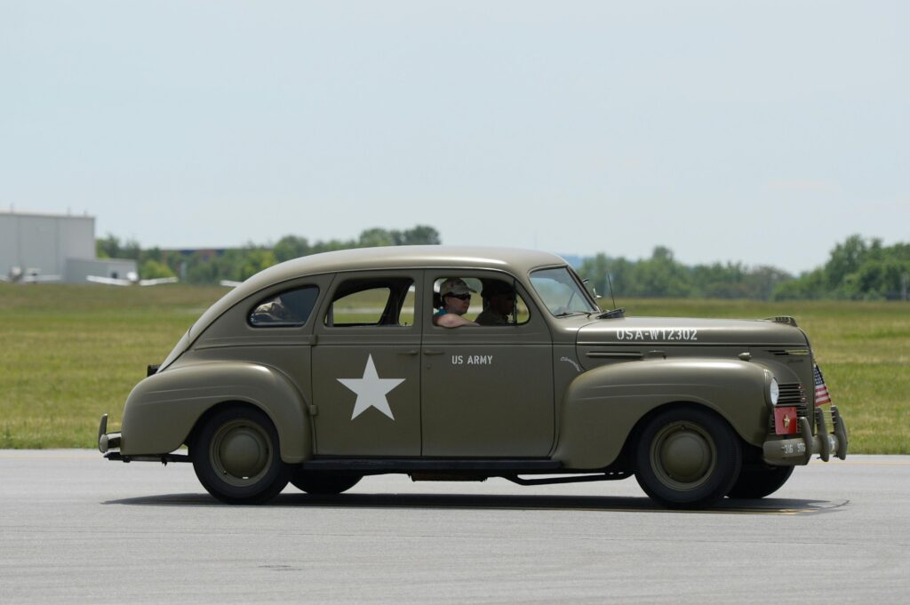 used cars in the USA Side view of a vintage US Army military vehicle in motion on a clear day.