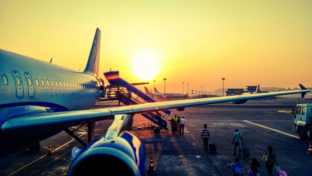 A vibrant image of passengers boarding an airplane at sunrise, highlighting air travel.