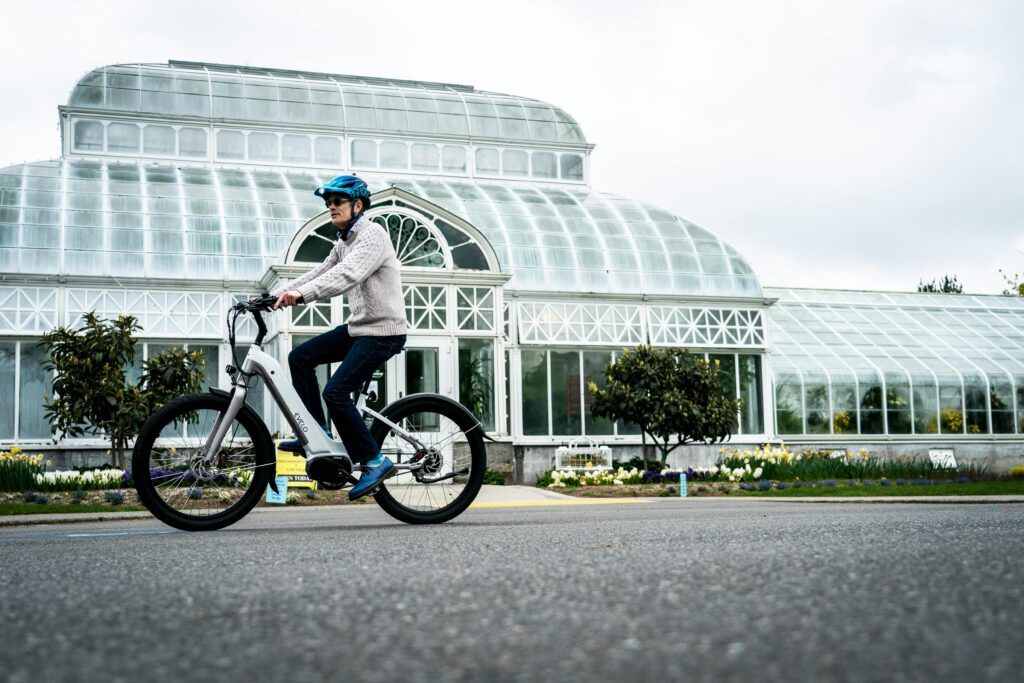 Adult riding an electric bike near a conservatory in Seattle.