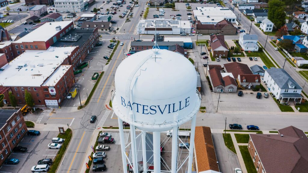From above of white tall contemporary water tower surrounded by roads and buildings