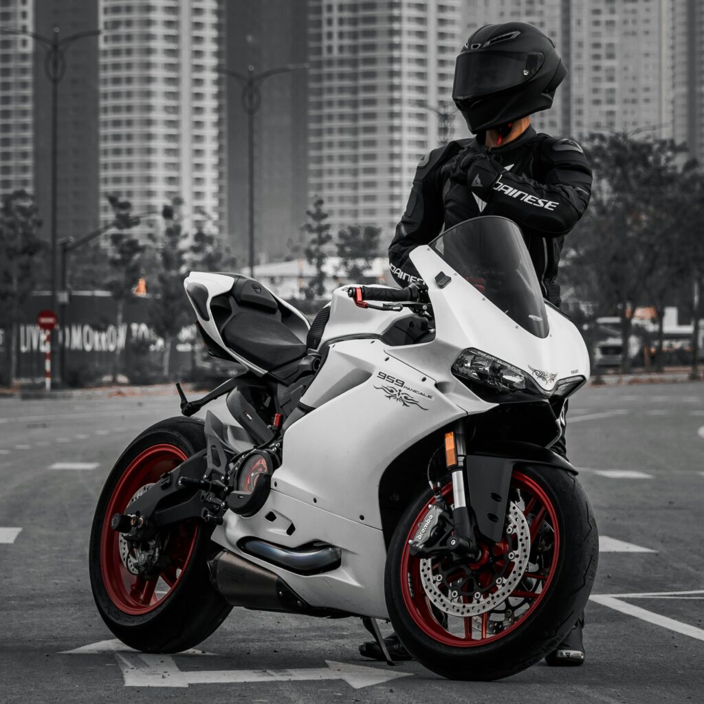 Motorbike rider in full gear with a Ducati Panigale in an urban setting.