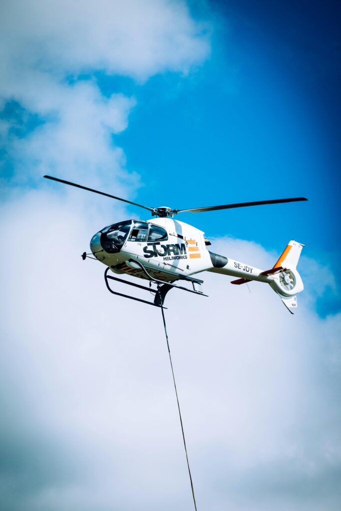 Electric Helicopters A helicopter in flight against a bright blue sky, showcasing aerial transport technology.
