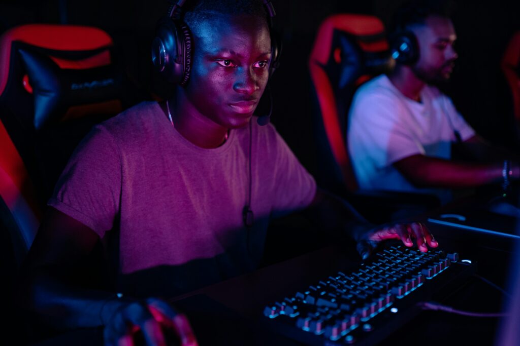 A serious gamer engaged in online esports, showcasing focus and determination under dramatic lighting.