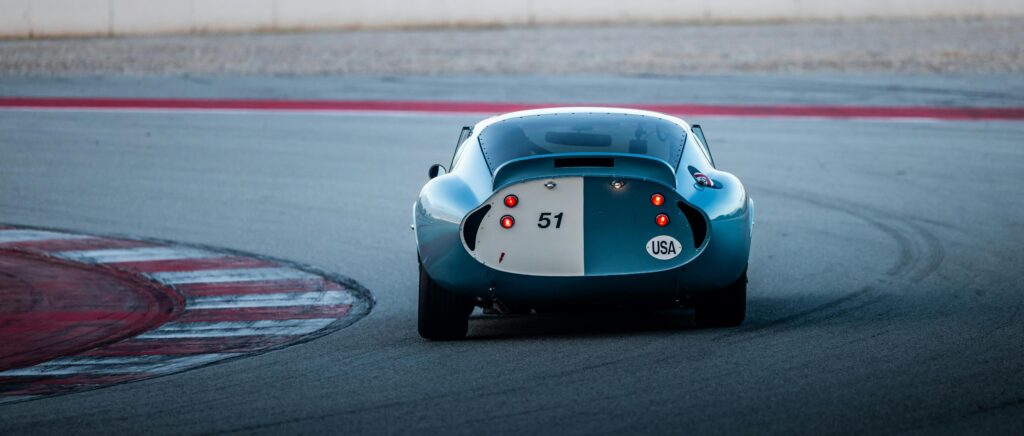 Classic racing car with number 51 on a track curve, USA at dusk.